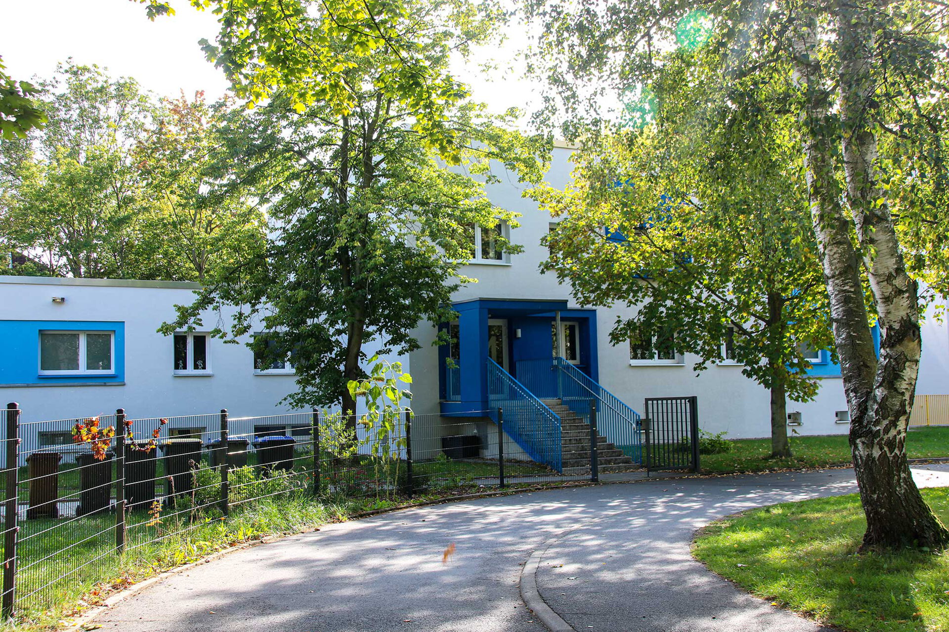 Außenansicht weißes Haus mit blauen Eingang Wilhelm-Firl-Straße 4.