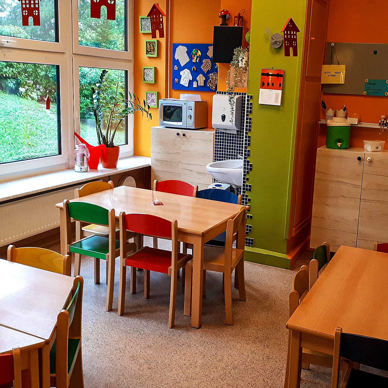 Das Kinderrestaurant mit drei Tischen mit Stühlen und Kommoden im Hintergrund an der Wand.