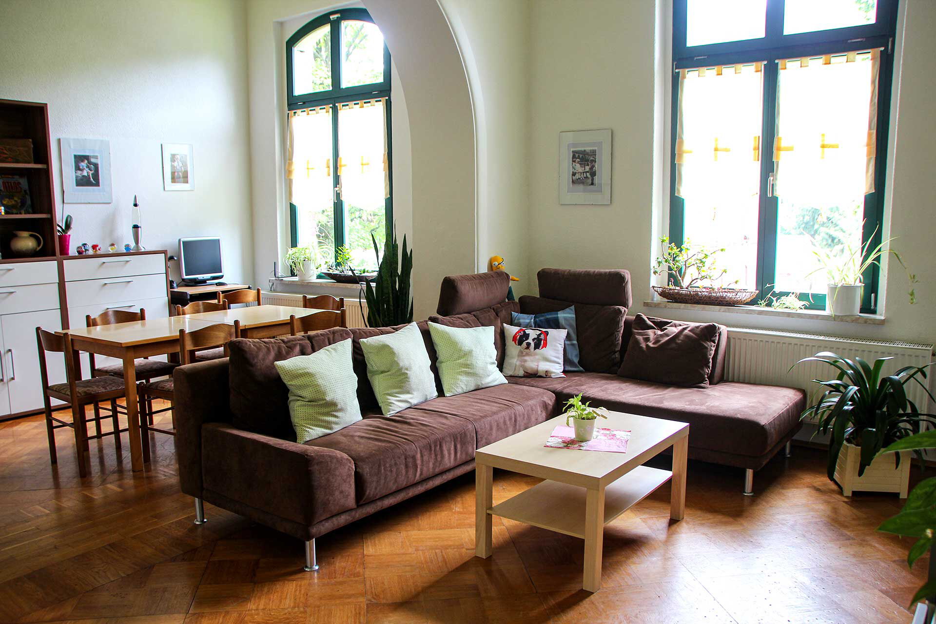 Ein großer Gruppenraum mit einer Wohnlandschaft und dem Spiel- und Hausaufgabenbereich.