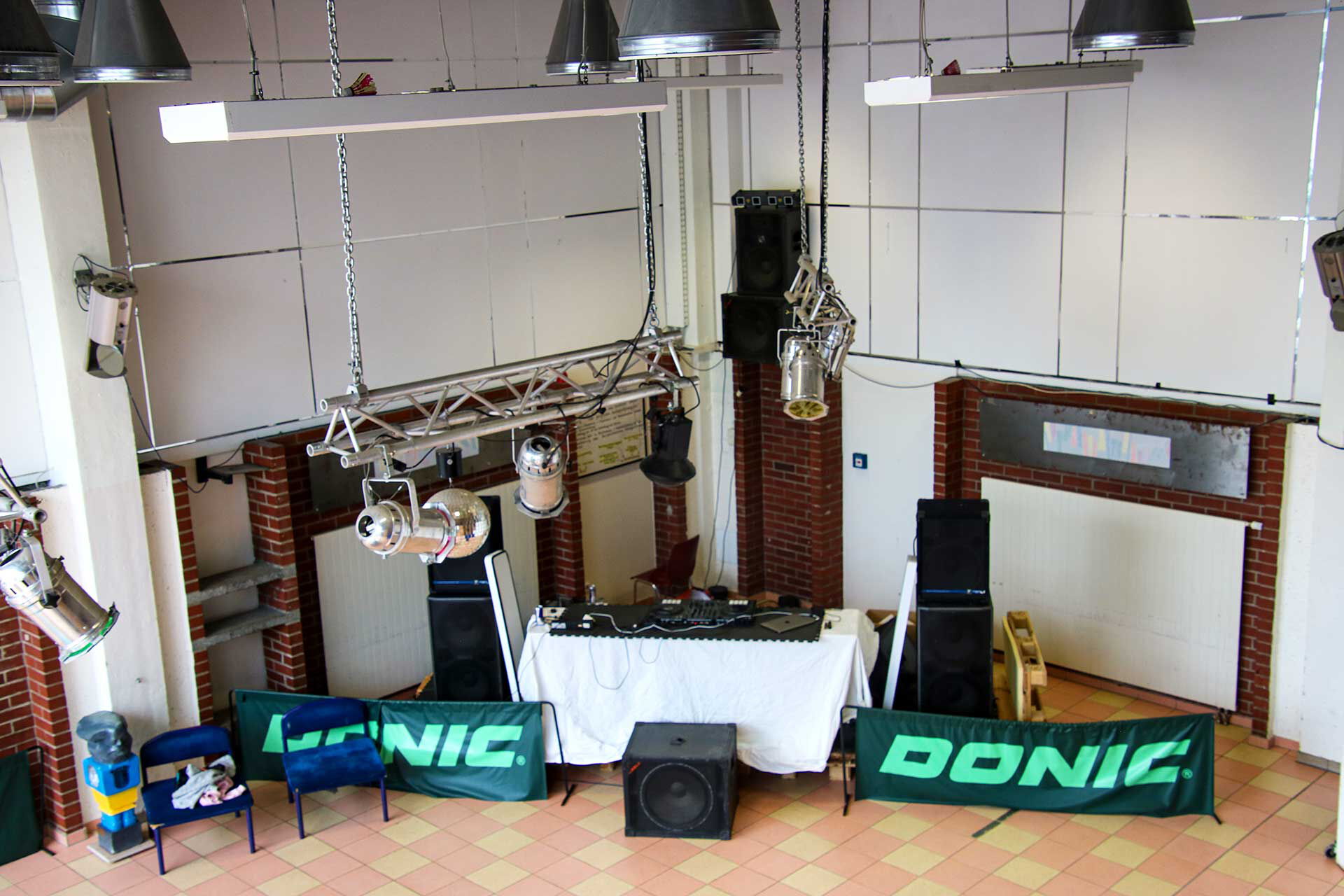 Der Diskjockeybereich mit mehreren Musikboxen, Mischpult und Beleuchtung.