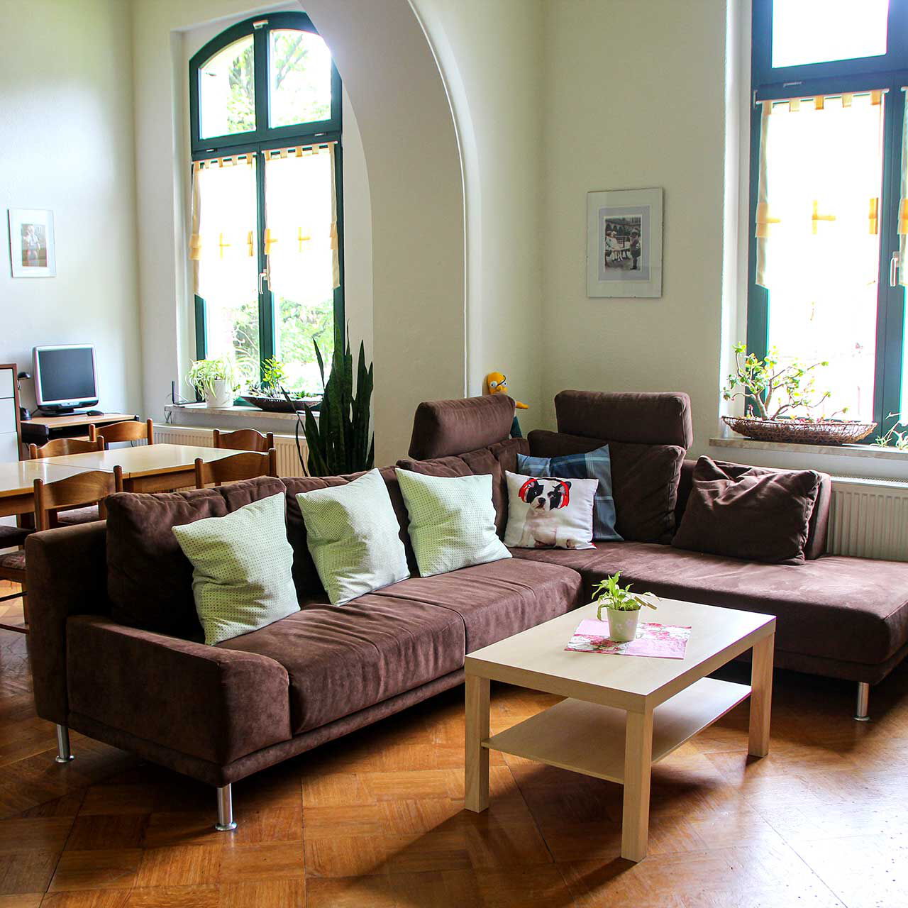 Ein großer Gruppenraum mit einer Wohnlandschaft und dem Spiel- und Hausaufgabenbereich.