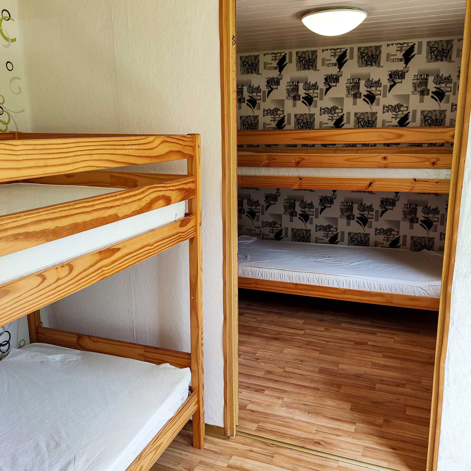 Der Innenbereich der Doppelhütte mit zwei Schlafräumen und jeweils einem Doppelstockbett.