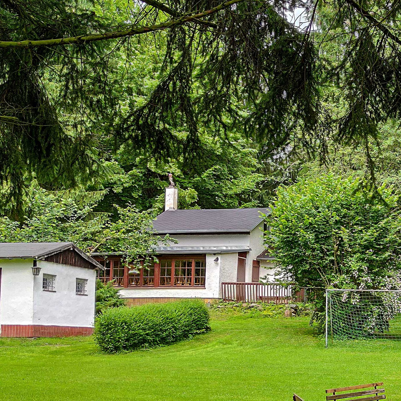 Das großzügige Außengelände mit einem kleinen Fußballplatz im Vordergrund und dem Haupthaus im Bildhintergrund.