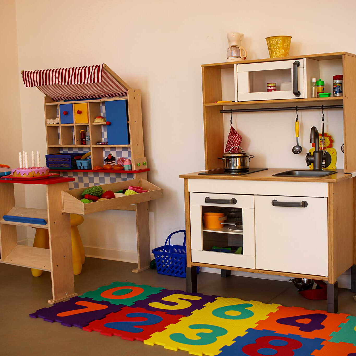 Eine Ecke des Spielzimmers mit Kinderspielküche und Einkaufsladen.