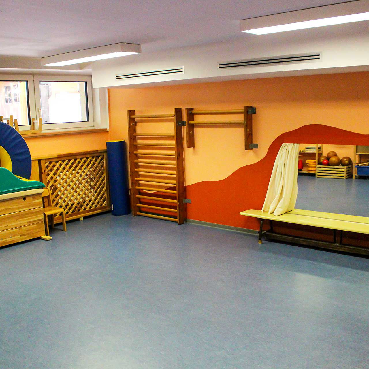 Ein Sportraum im Keller mit Sportgeräten, Turnbänken und Sprossenwänden.