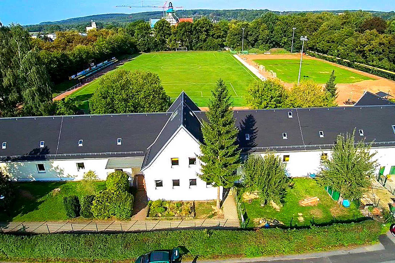 Das Hauptgebäude der Kita von oben mit Blick Richtung der Grundschule.