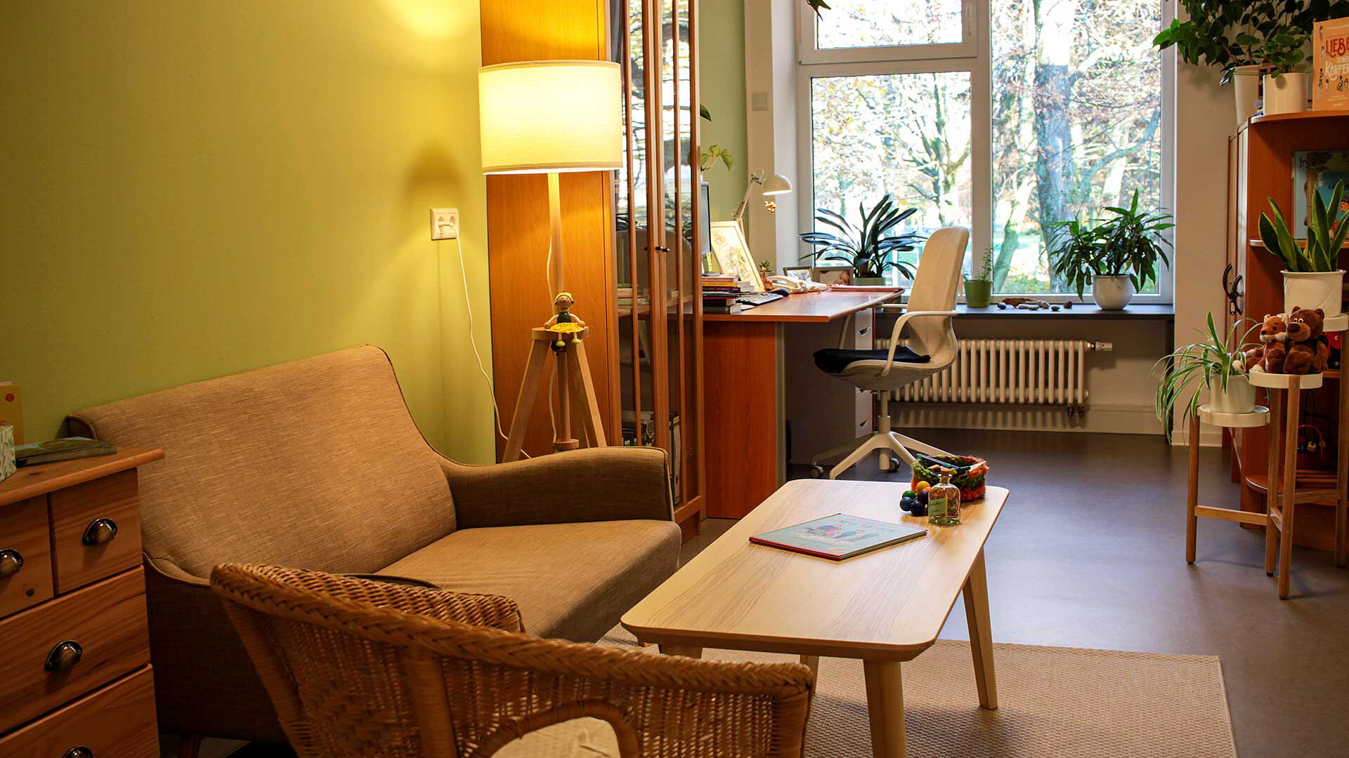 Ein Bürozimmer mit einer kleinen Sitzecke und einen Schreibtisch für Büroarbeiten.
