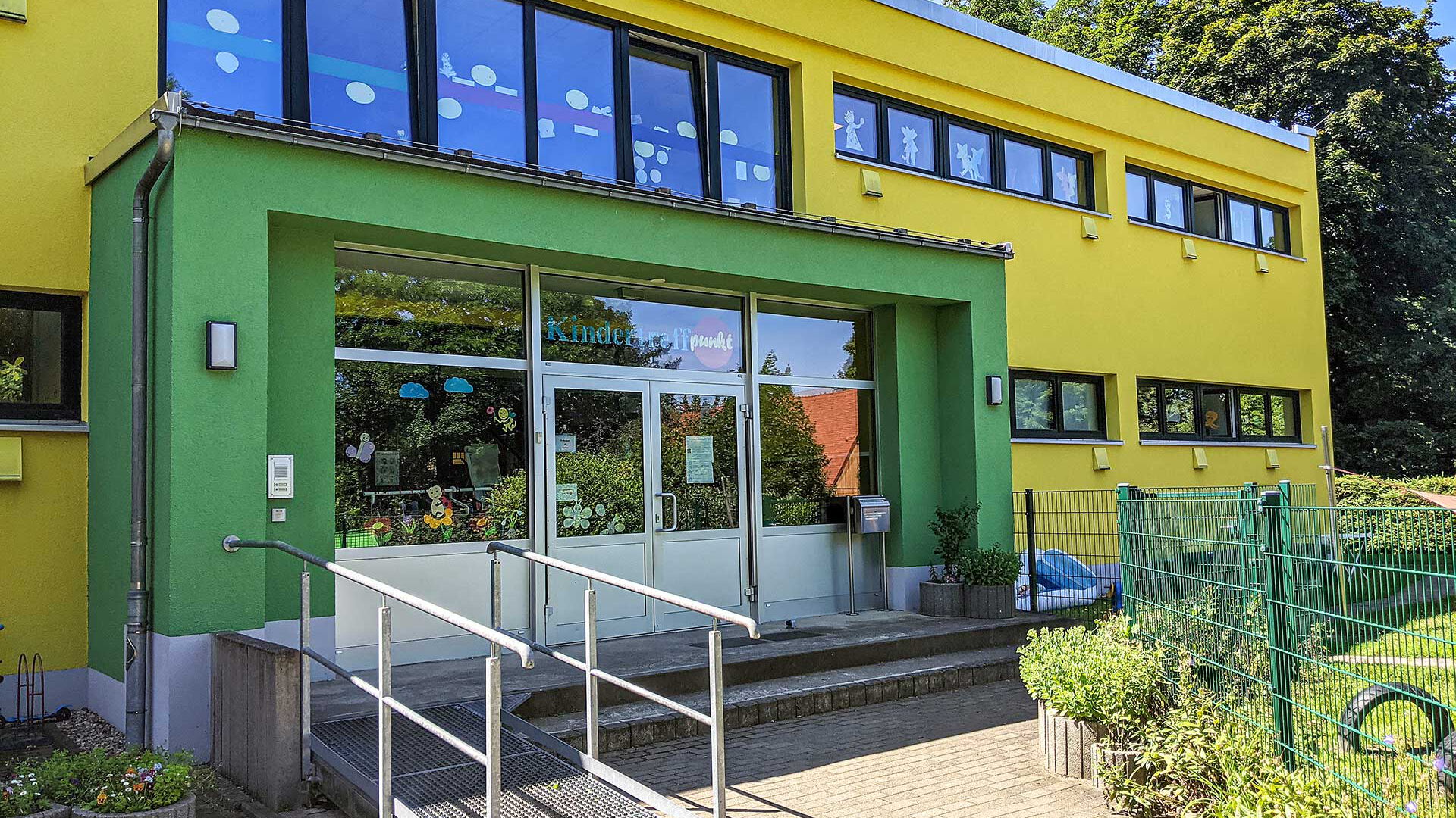 Der Eingang der Kindertageseinrichtung Kindertreffpunkt mit einer Rampe und Treppe.