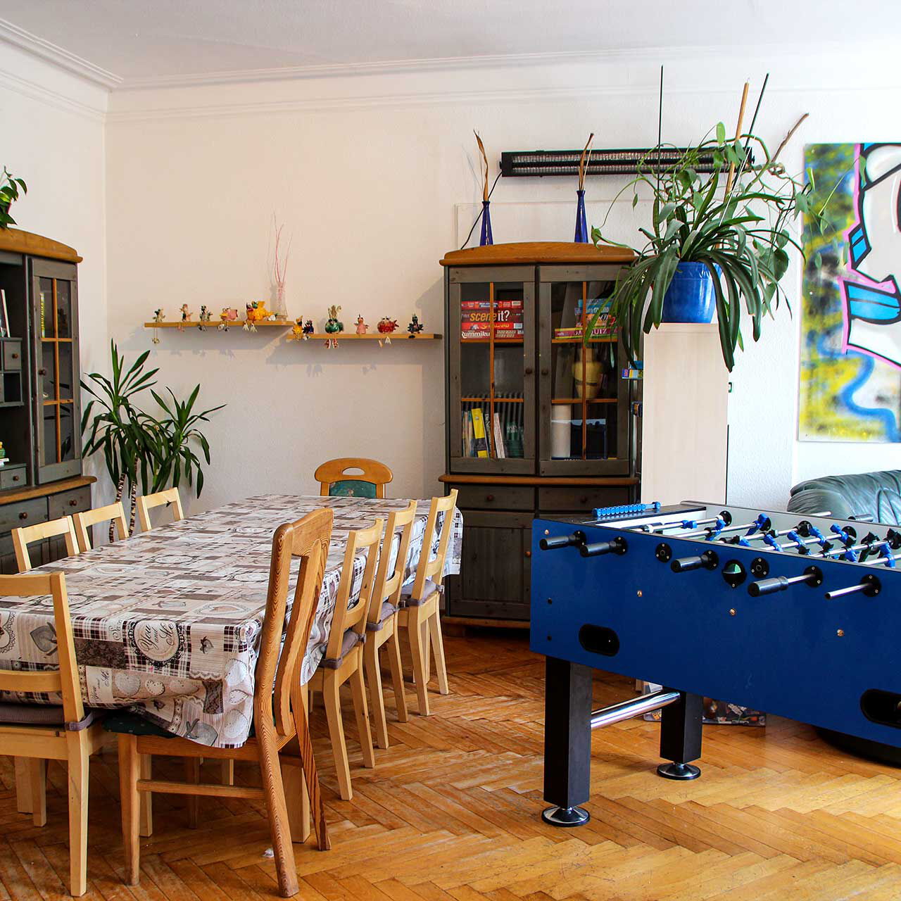 Der Gruppenraum mit Tischkicker, Tisch mit neun Stühlen und Ledersofa.