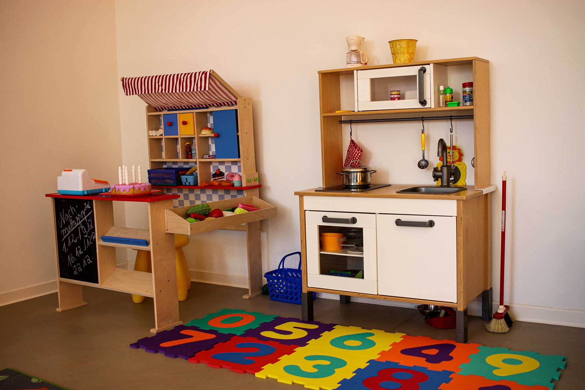 Eine Ecke des Spielzimmers mit Kinderspielküche und Einkaufsladen.