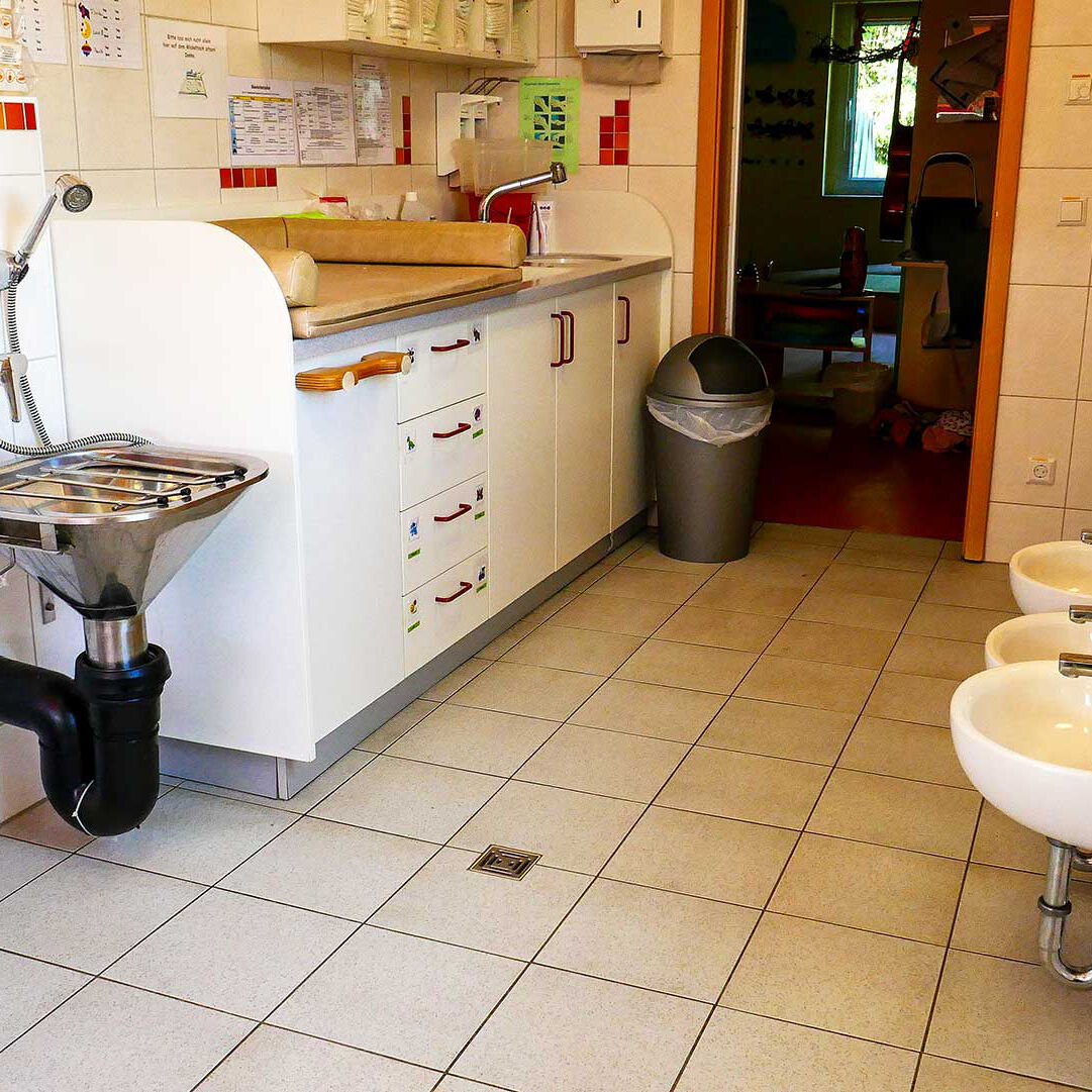 Das Bad im Kleinkindbereich mit drei Kinderwaschbecken, einer Kindertoilette und Wickeltisch.