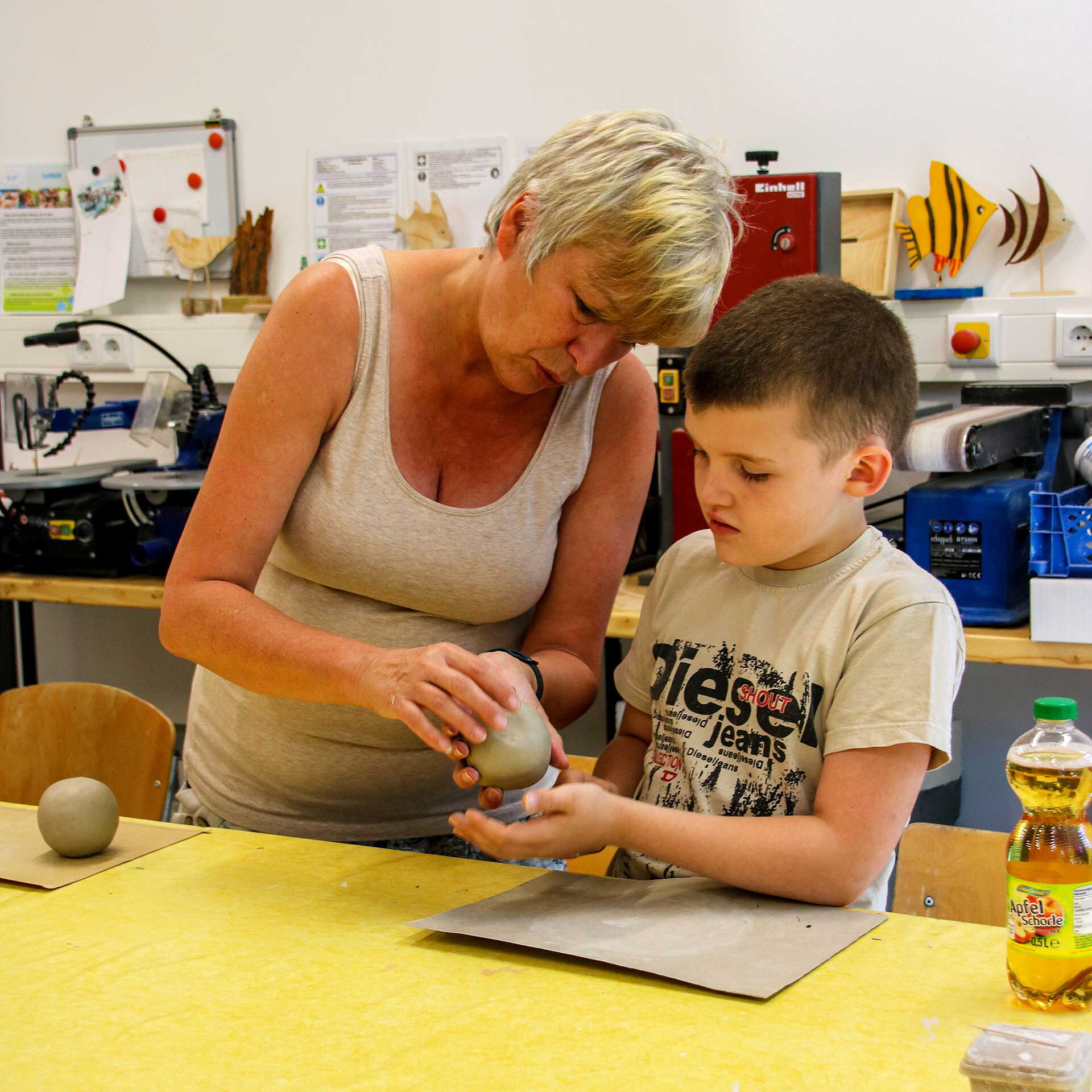 Ein Kind bearbeitet Ton in der Keramikwerkstatt.