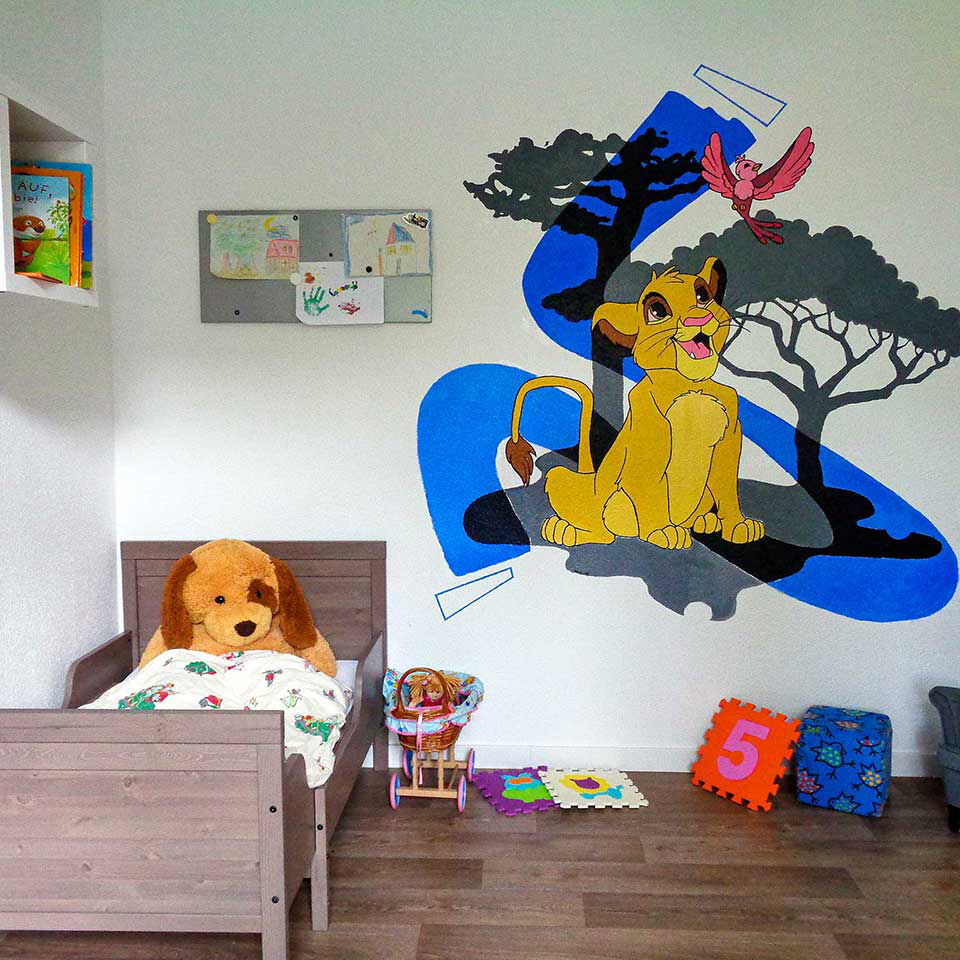 Ein Kinderzimmer mit Kinderbett, Sessel, Wandboard, Puppenwagen und König der Löwen Wandbemalung.